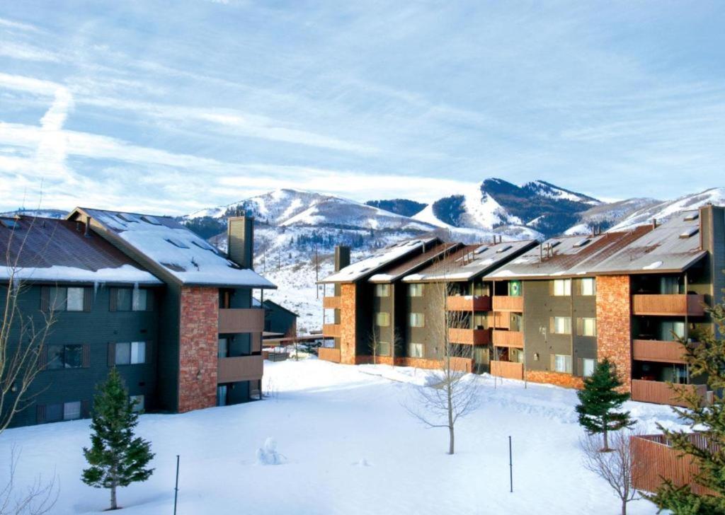 a building in the snow with mountains in the background at PowderWood in Kimball Junction