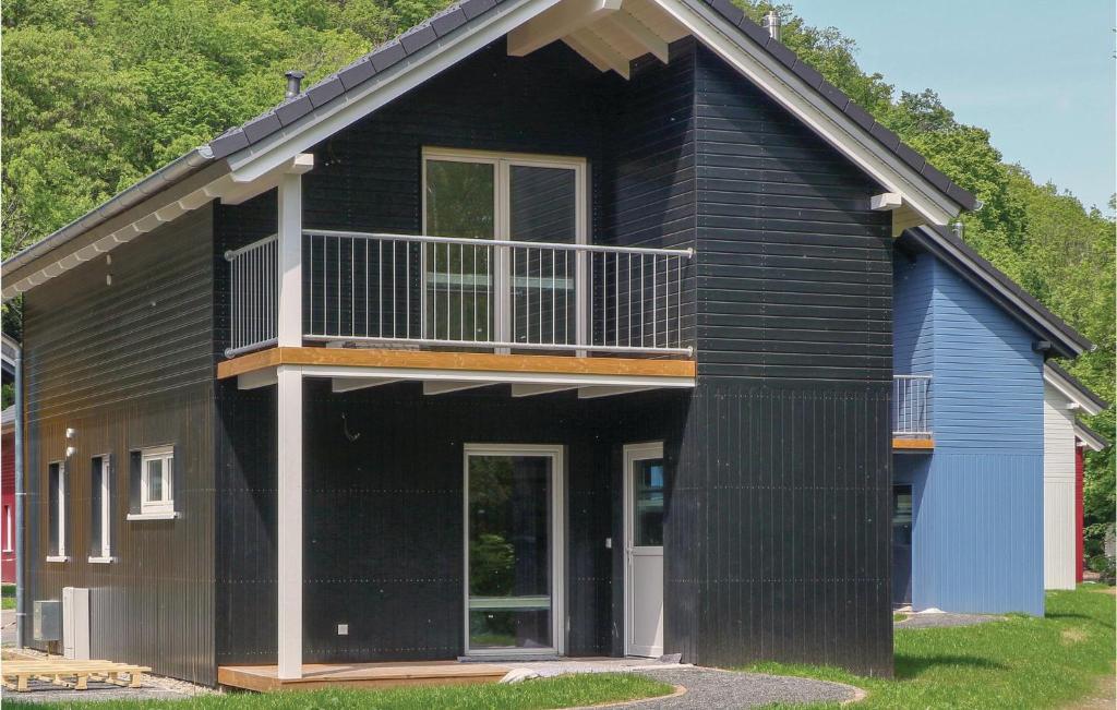 a black house with a balcony on top of it at Ferienhausdorf Thale in Thale