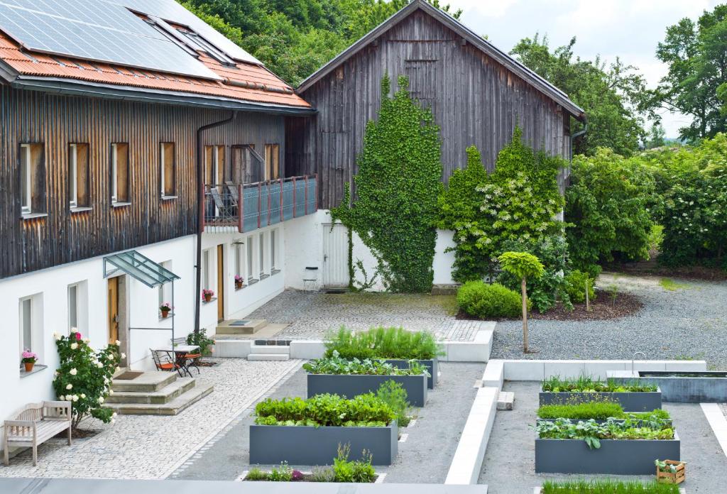 un jardín frente a un edificio con plantas en Biohotel Pausnhof en Sankt Oswald