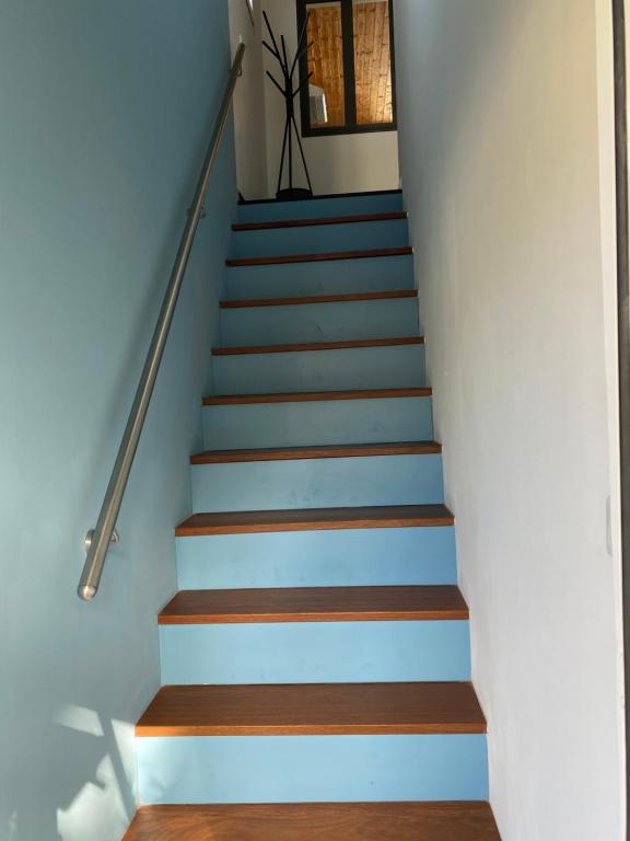 a staircase with blue and brown wooden floors at Location saisonnière A portée de vue in La Possession