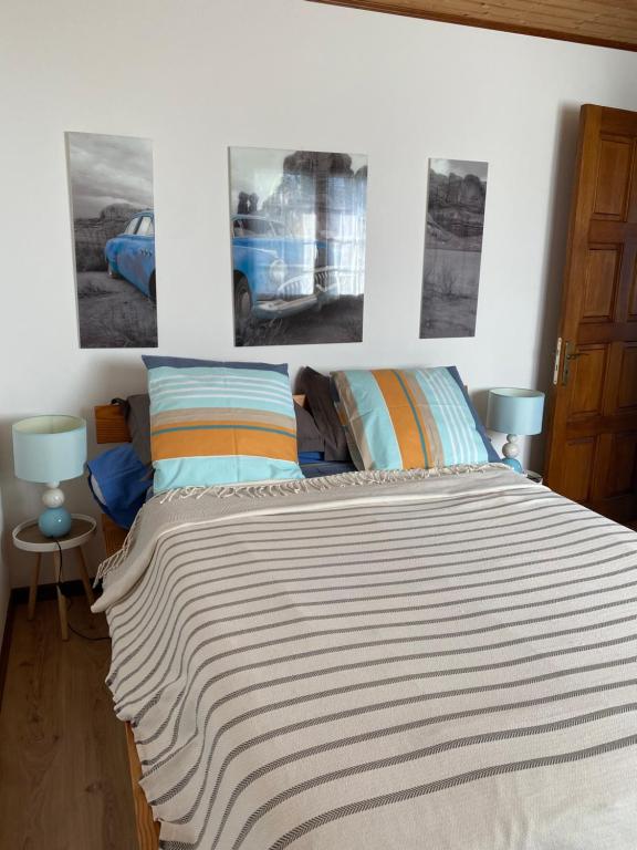 a bedroom with a bed with two pictures on the wall at Location saisonnière A portée de vue in La Possession
