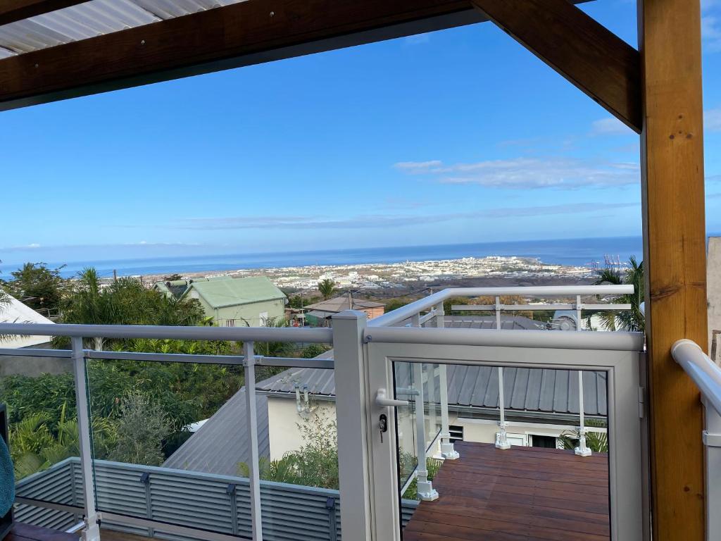 a balcony with a view of the ocean at Location saisonnière A portée de vue in La Possession