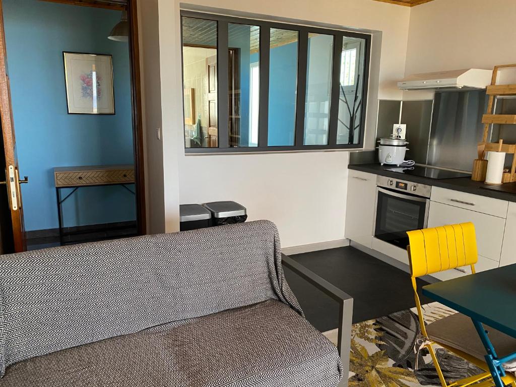 a kitchen with a couch and a table in a room at Location saisonnière A portée de vue in La Possession