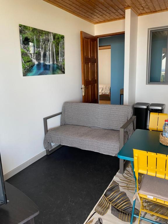 a living room with a couch and a table at Location saisonnière A portée de vue in La Possession