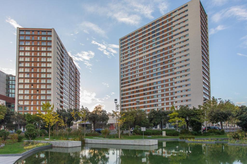 two tall buildings next to a body of water at Your Lisbon Home Parque das Nações in Lisbon