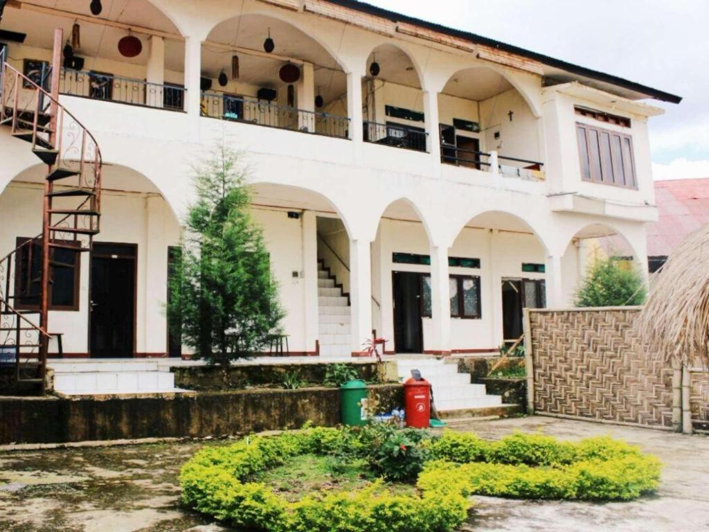 een wit huis met een brandkraan ervoor bij FX 72 Ruteng Hotel in Ruteng