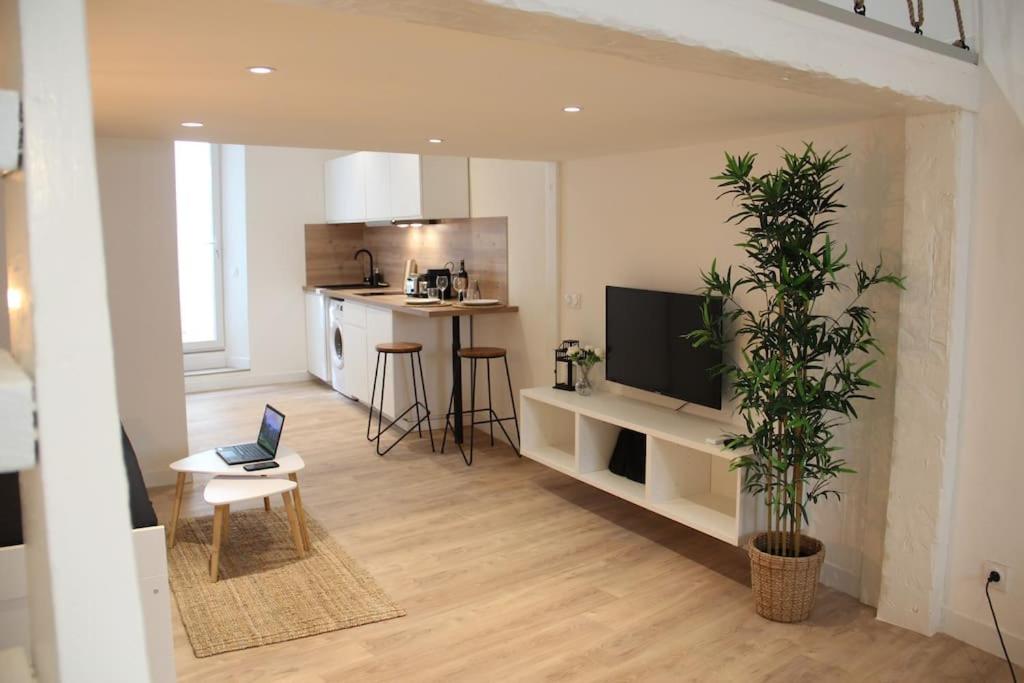 un salon avec un ordinateur portable posé sur une chaise dans l'établissement Le bambou - Appartement avec terrasse, à Marseille