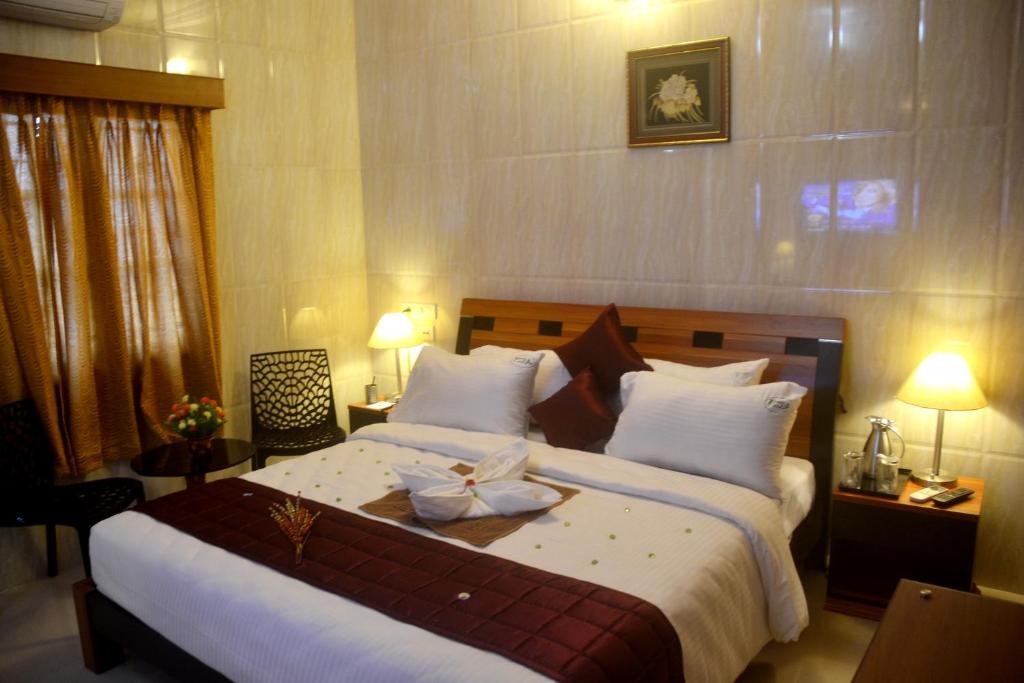 una camera da letto con un grande letto con un arco sopra di Peace Inn Chennai a Chennai