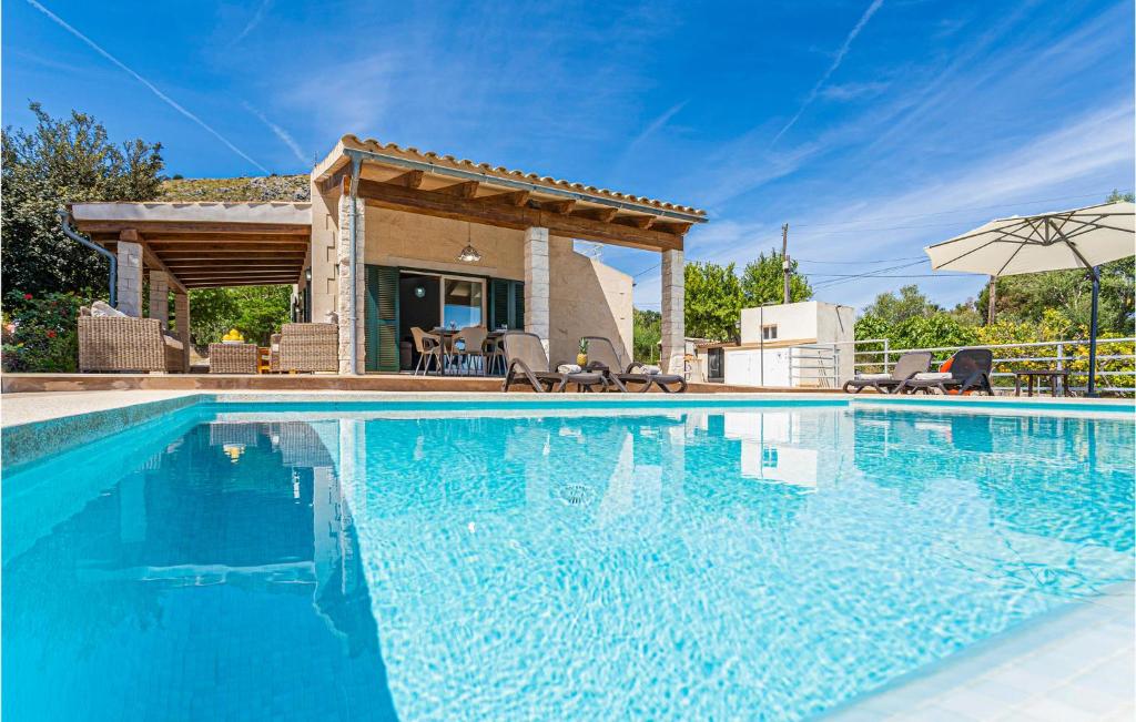 a swimming pool in front of a villa at Cozy Home In Puerto De Alcudia in Port d'Alcudia