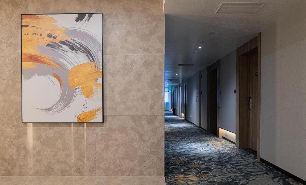 a hallway in a building with a painting on the wall at hailihotel in Dongguan