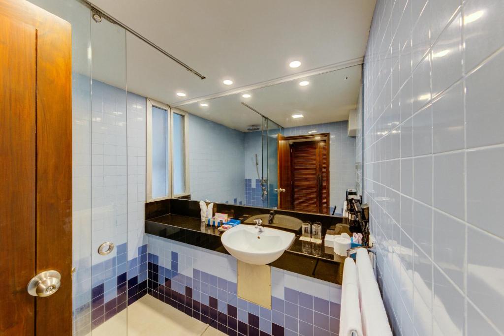 a bathroom with a sink and a mirror at Hikka Tranz by Cinnamon in Hikkaduwa