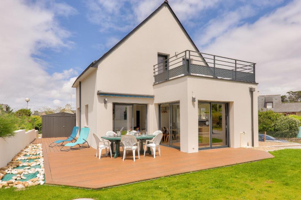 une maison avec une terrasse avec une table et des chaises dans l'établissement Maison avec jardin - à 400m plage des Govelins, à Saint-Gildas-de-Rhuys