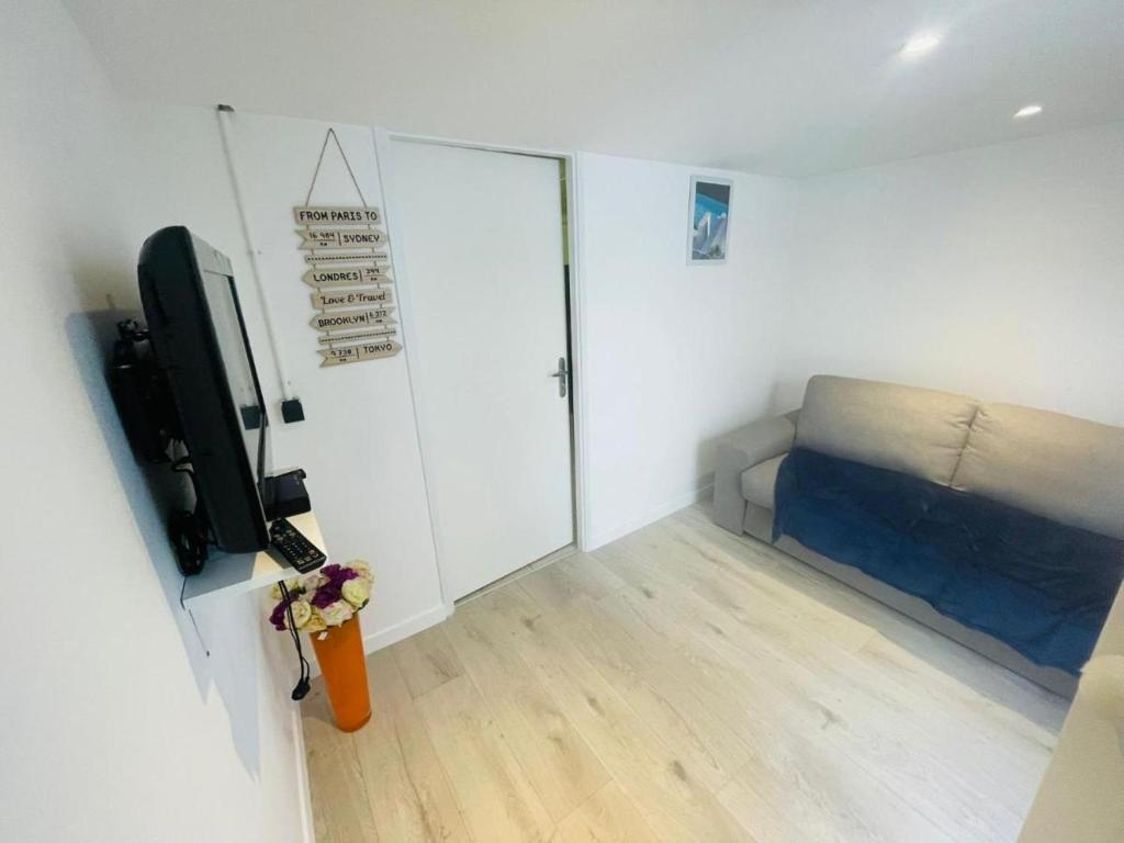 une petite chambre avec un lit et une télévision dans l'établissement F2 aux porte de Paris - 4 pers, à Champigny-sur-Marne