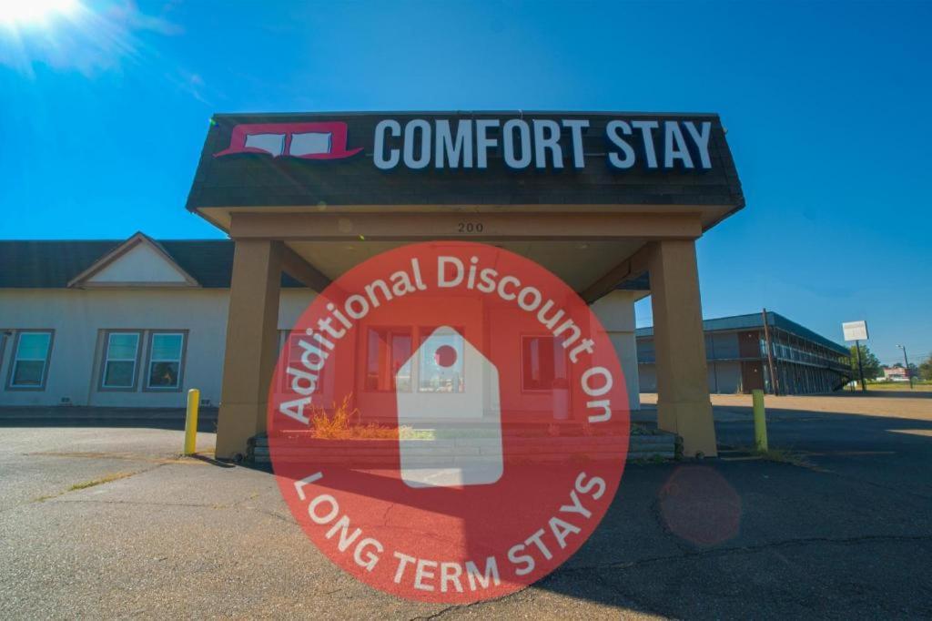 a sign for a comforent shop in a parking lot at Hotel Comfort Stay by OYO Texarkana East, AR I-30 in Whatley