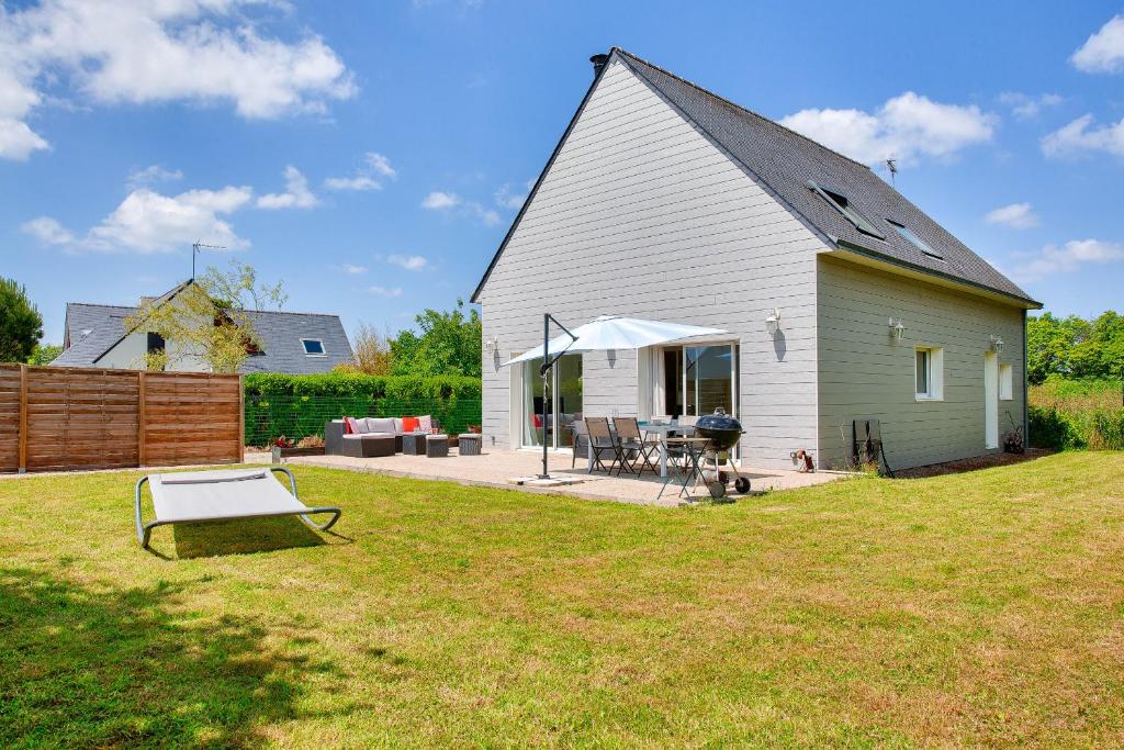 une grange avec une table et un gril dans une cour dans l'établissement Grande maison et beau jardin pour 8, à Clohars-Fouesnant