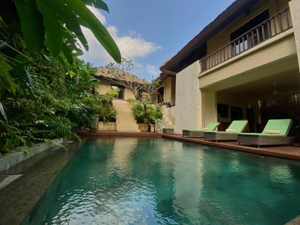 a swimming pool in front of a house at Villa Purnamasari in Ubud