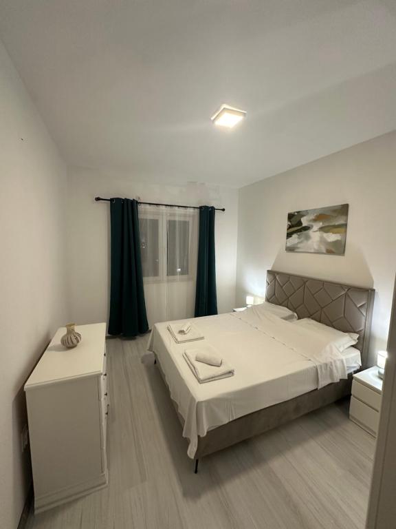 a bedroom with a large white bed and a window at Apartman SANT Herceg Novi in Herceg-Novi