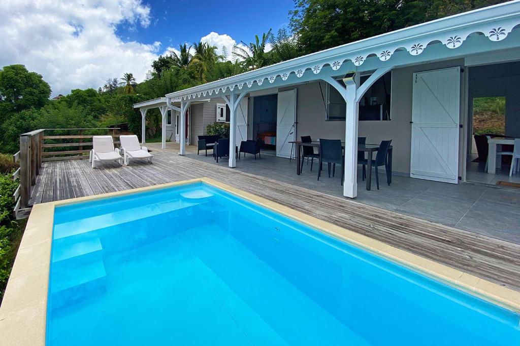 una piscina en una terraza de madera junto a una casa en Ti sunset et bungalow 2 chambres, en Le Carbet