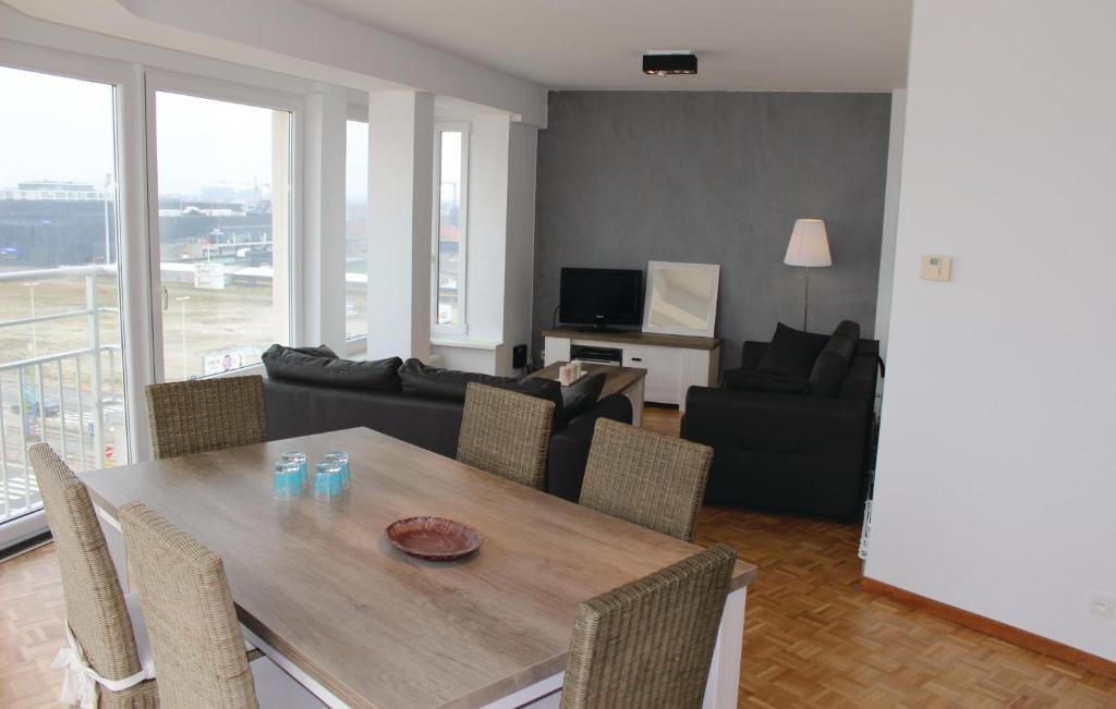 un salon avec une table et des chaises en bois dans l'établissement Residentie Acapulco 6B, à Ostende