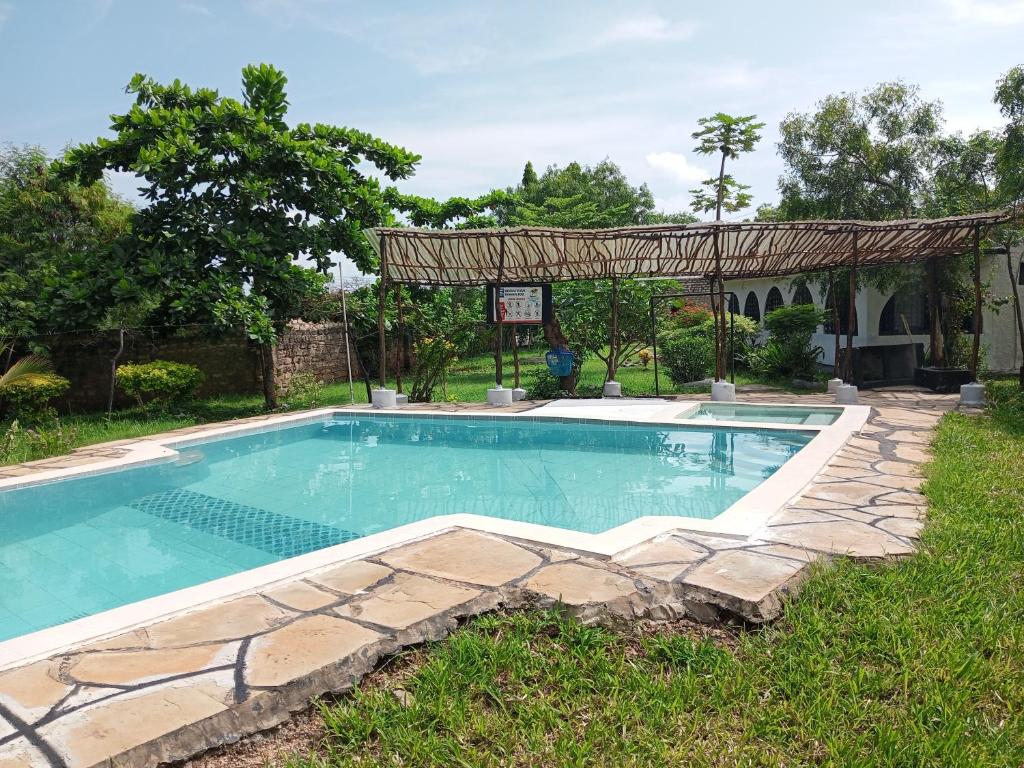 una piscina in un cortile con gazebo di Fred Hunter Villa a Tiwi