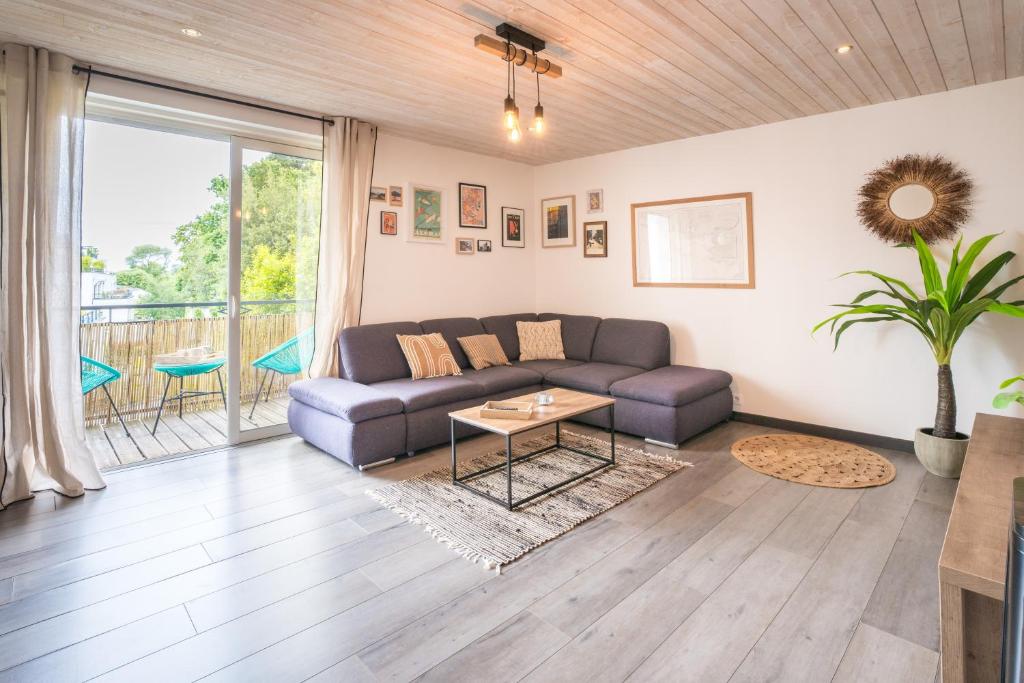 un salon avec un canapé et une table dans l'établissement Le Ferdinand - Appt lumineux centre-ville Vannes, à Vannes