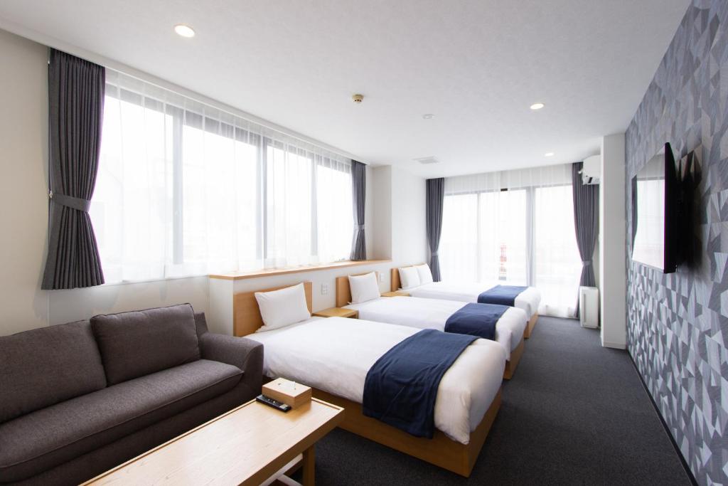 una habitación de hotel con dos camas y un sofá en Neo Field Nakasu, en Fukuoka