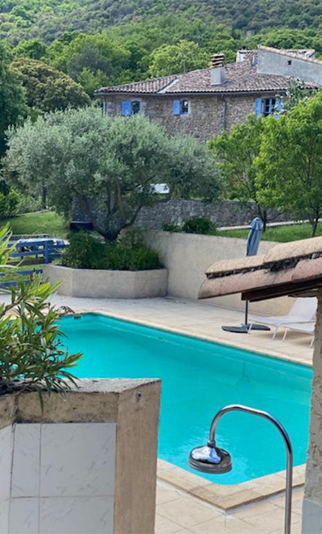 une piscine avec un banc à côté d'une maison dans l'établissement Mas le Canton, à Saint-Jean-du-Gard