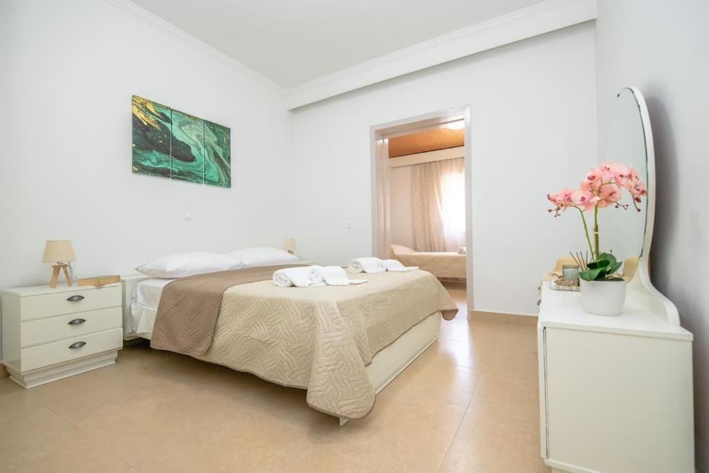 ein weißes Schlafzimmer mit einem Bett und einem Spiegel in der Unterkunft Ntina's Apartment in Rhodos (Stadt)