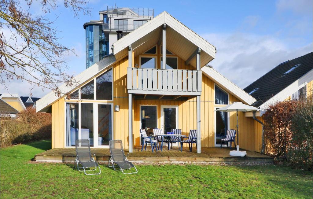 a yellow house with a table and chairs in a yard at 2 Bedroom Stunning Home In Rechlin in Zielow