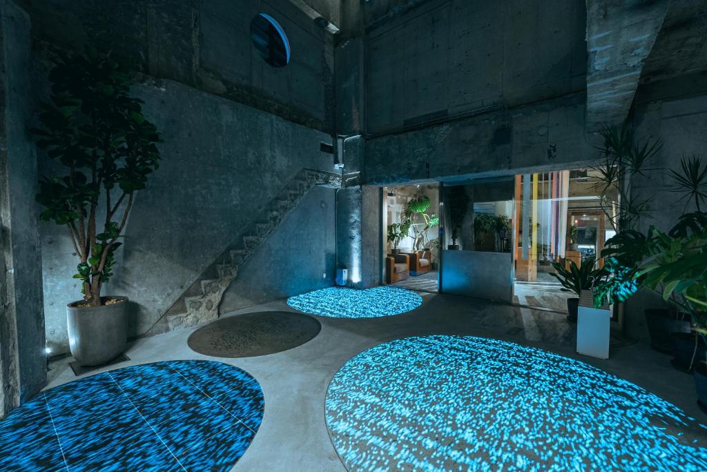 a room with three blue rugs on the floor at Of Hotel in Sendai