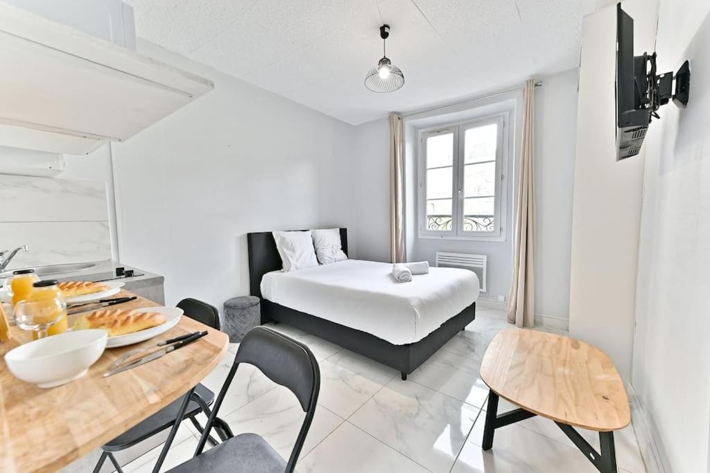 une chambre blanche avec un lit, une table et des chaises dans l'établissement Agréable Studio #Montmartre #SacréCœur, à Paris
