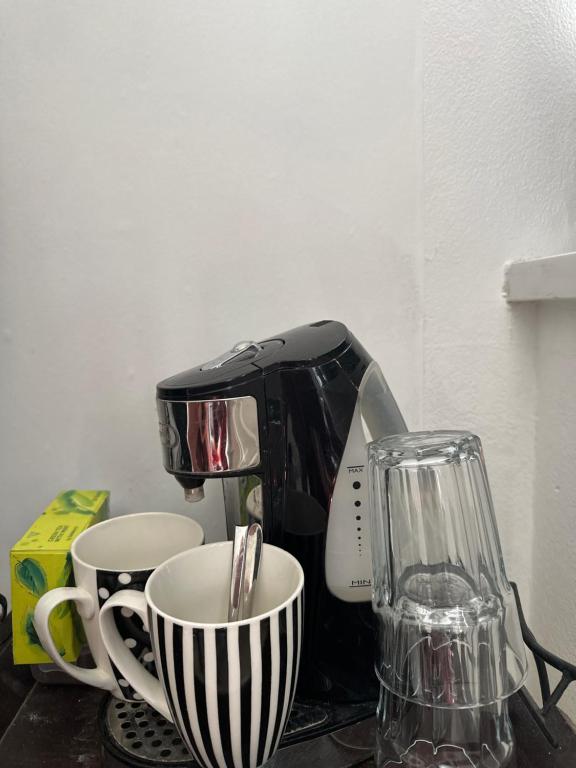 a coffee maker and two cups on a table at Alexandra Palace White Hart Lane Twin room in London