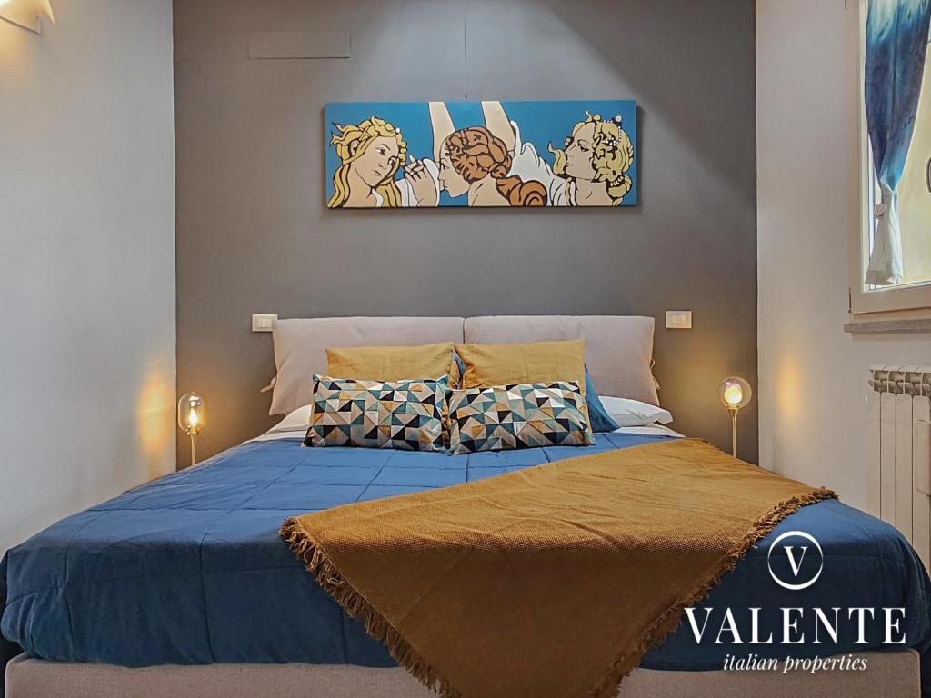 a bedroom with a bed with a blue comforter at Lamante apartment in Lucca in Lucca