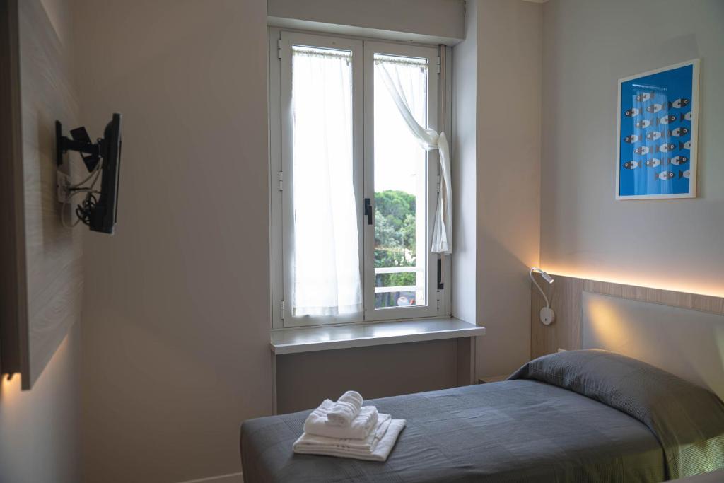a bedroom with a bed and a window at Hotel Tritone in Trieste