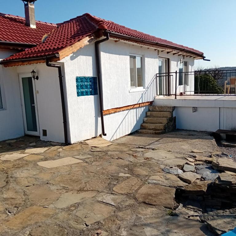 a house with a stone patio in front of it at Salasuka Views in Dryanovo