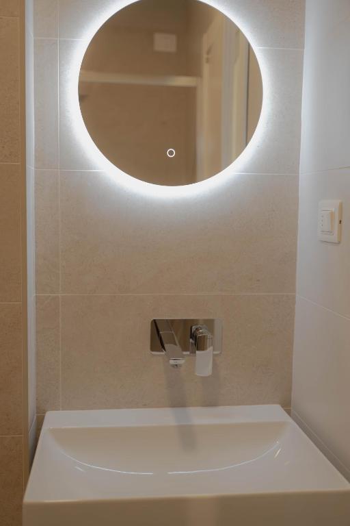 a bathroom with a sink and a mirror at Hotel Tritone in Trieste