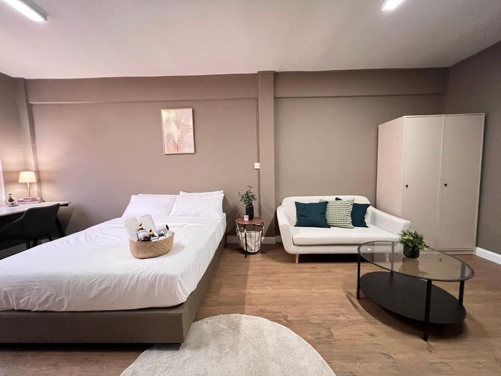 曼谷Hi Life Sukhumvit 65的一间卧室，里面有一张床、一张沙发和一张桌子