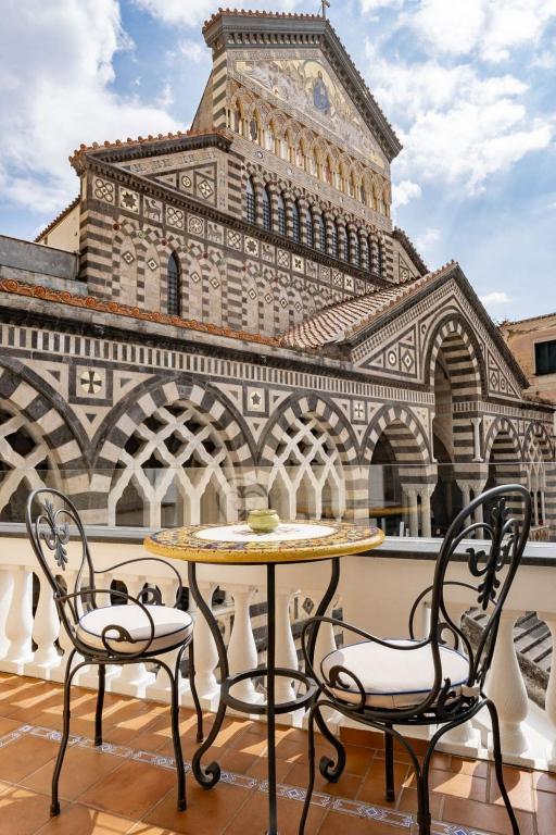 a table and two chairs in front of a tower at La Suite Del Cavaliere in Amalfi