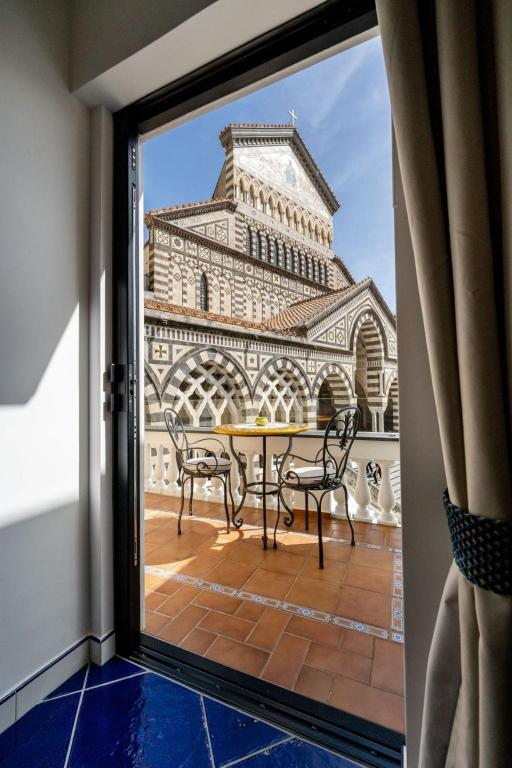 a balcony with a table and chairs in front of a building at La Suite Del Cavaliere in Amalfi