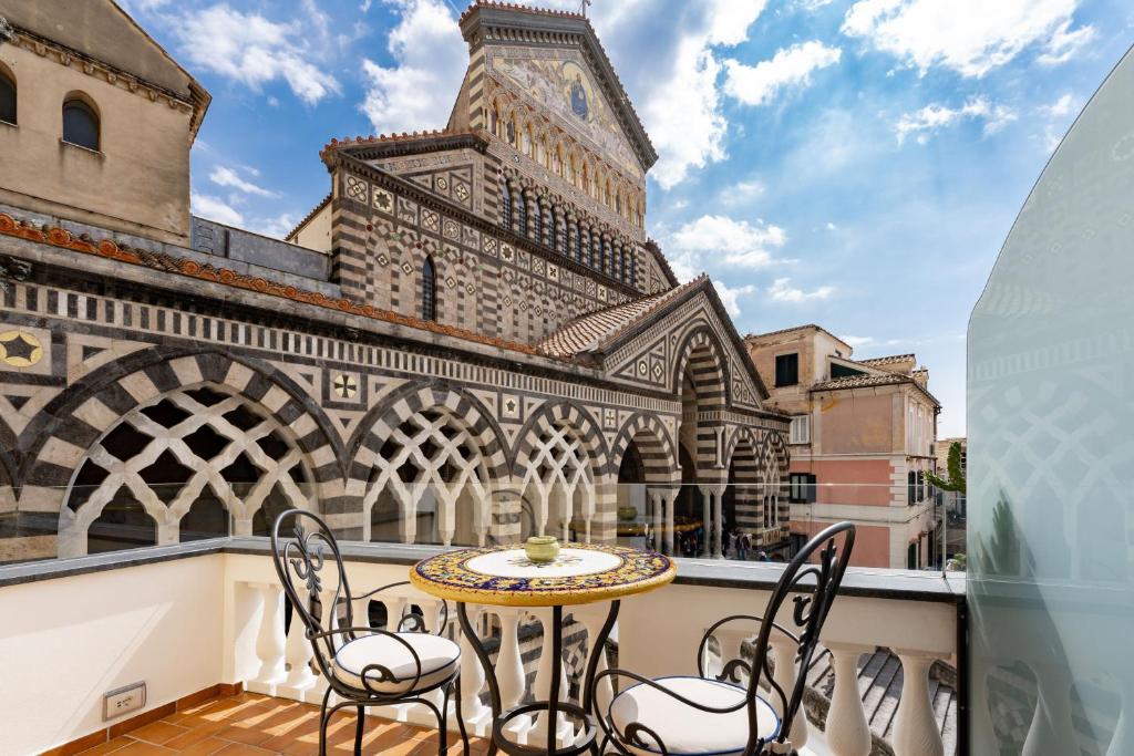 a balcony with a table and chairs and a clock tower at La Suite Del Cavaliere in Amalfi