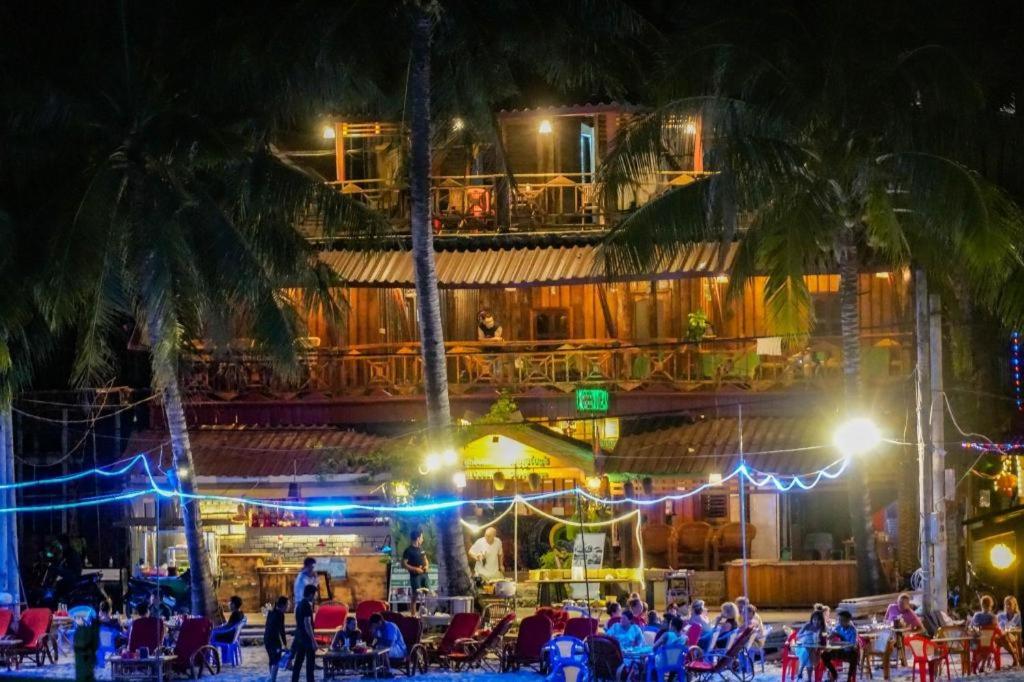 people sitting in chairs in front of a building at night at Green Ocean Koh Rong in Koh Rong Island