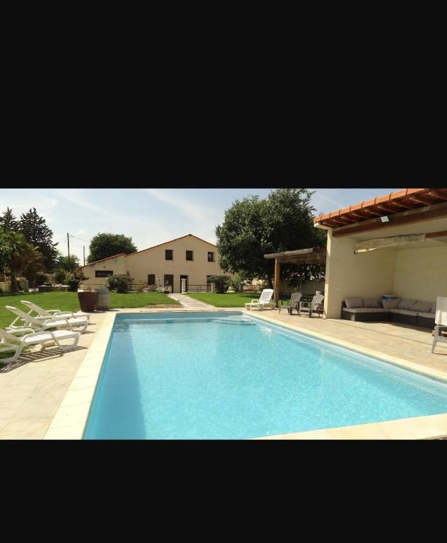une grande piscine avec des chaises et une maison dans l'établissement Villa 190 m avec Piscine proche Aix-en-Provence, à Éguilles