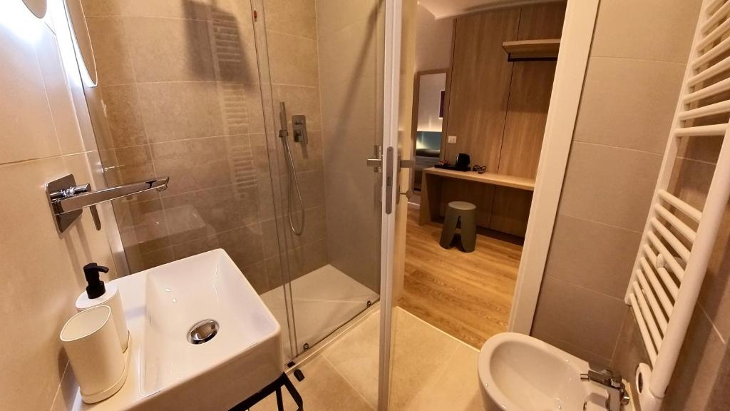 a bathroom with a shower and a sink and a toilet at Hotel Tritone in Trieste