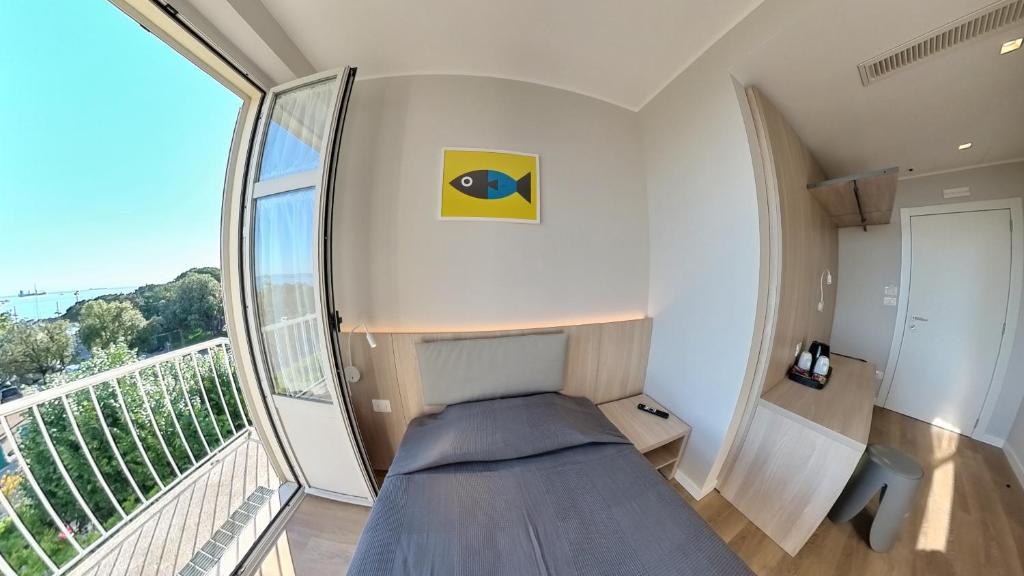 a small bedroom with a bed and a balcony at Hotel Tritone in Trieste