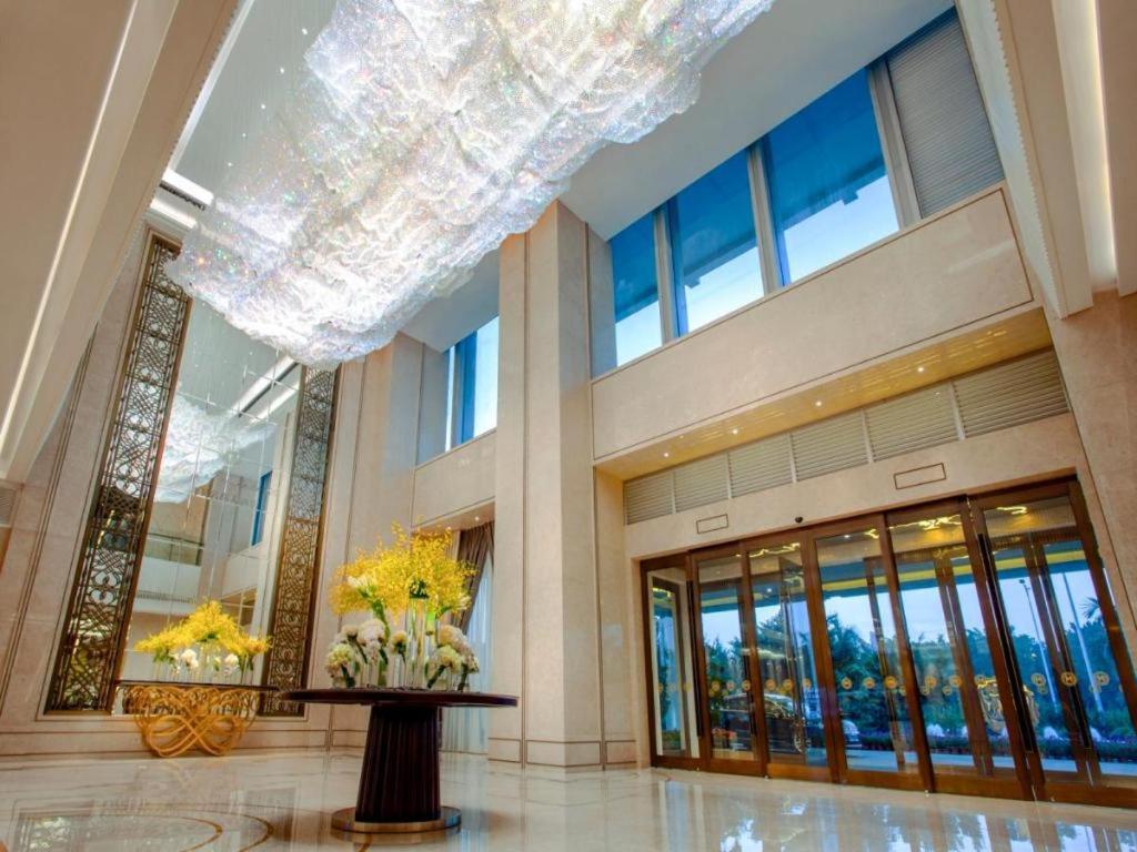 eine Lobby mit einem großen Kronleuchter in einem Gebäude in der Unterkunft Ming Du Lakeside Hotel Nanning in Nanning