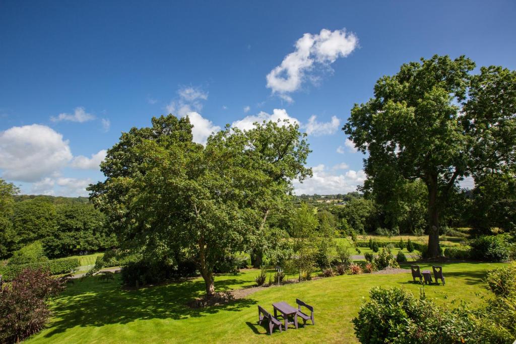 a park with benches and trees on a field at Penbontbren Luxury Bed and Breakfast in Aberporth