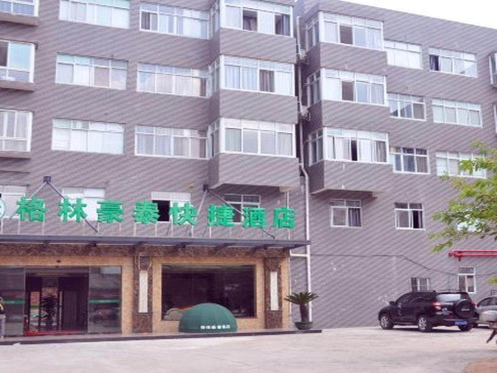 a tall building with green writing on it at GreenTree Inn Ganzhou Sankang Temple DaRunFa Express Hotel in Ganzhou