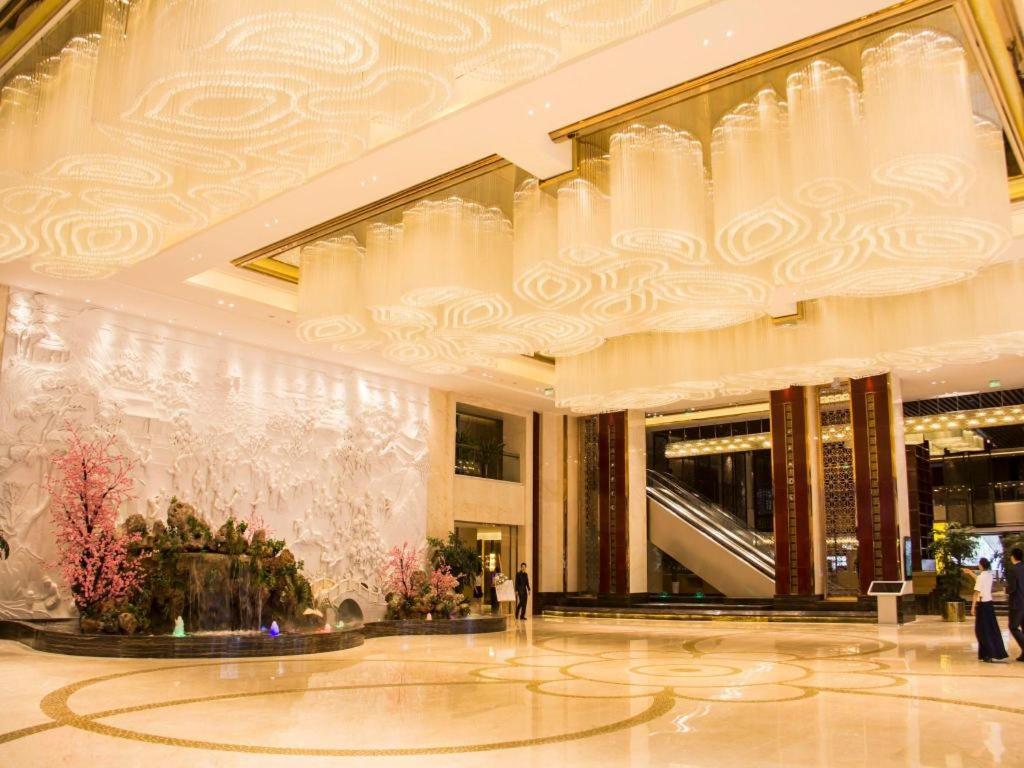 eine Lobby eines Gebäudes mit einem Kronleuchter in der Unterkunft Chengdu Charming Yard Nature Nook Hotel in Chengdu