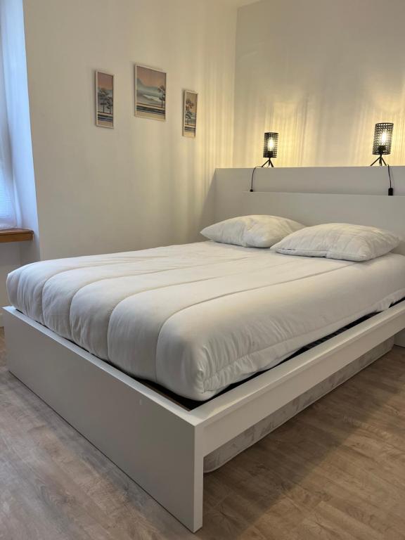 un lit blanc avec deux lampes dessus dans l'établissement KerKolina, à Cancale
