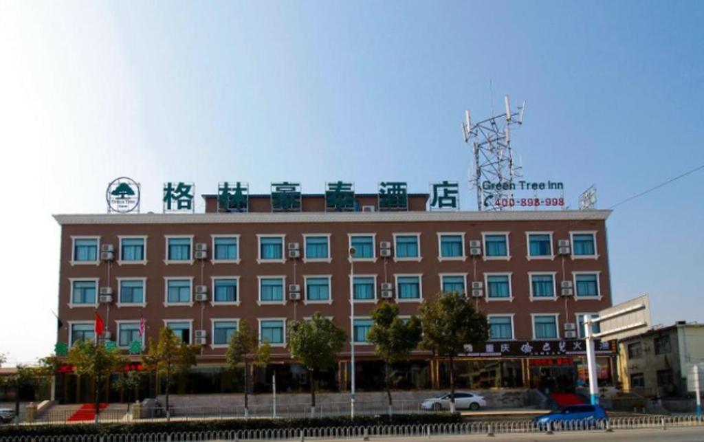a large building with a sign on top of it at GreenTree Inn HeFei LongChuan Road South Hefei Railway Station Business Hotel in Hefei